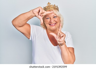 Middle Age Blonde Woman Wearing Queen Crown Smiling Making Frame With Hands And Fingers With Happy Face. Creativity And Photography Concept. 