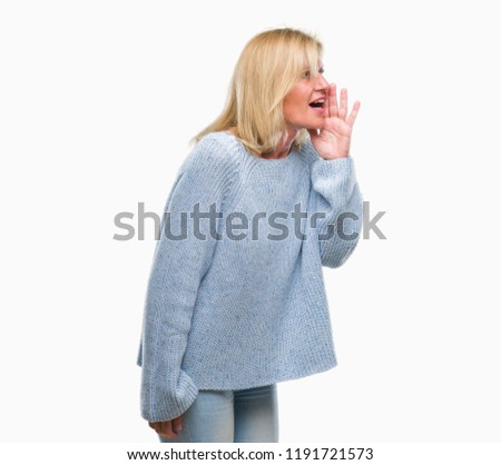 Middle age blonde woman wearing winter sweater over isolated background shouting and screaming loud to side with hand on mouth. Communication concept.