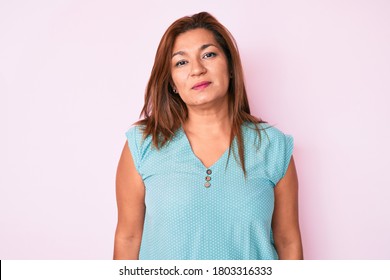 Middle Age Brunette Hispanic Woman Wearing Casual Clothes Relaxed With Serious Expression On Face. Simple And Natural Looking At The Camera. 