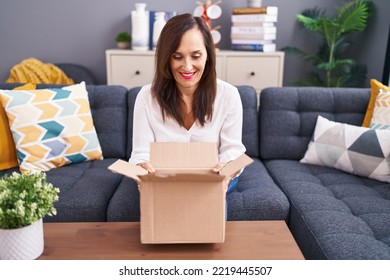 Middle Age Brunette Woman Opening Cardboard Box Smiling With A Happy And Cool Smile On Face. Showing Teeth. 