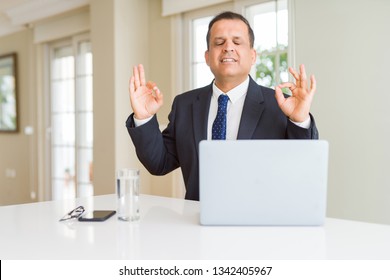 Middle Age Business Man Working With Computer Laptop Relax And Smiling With Eyes Closed Doing Meditation Gesture With Fingers. Yoga Concept.