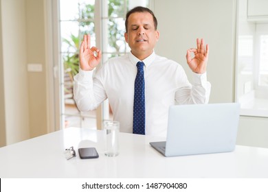 Middle Age Business Man Working With Computer Laptop Relax And Smiling With Eyes Closed Doing Meditation Gesture With Fingers. Yoga Concept.