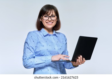 Middle Age Business Woman Using Laptop, Looking At Camera On Light Background