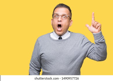 Middle age bussines arab man wearing glasses over isolated background pointing finger up with successful idea. Exited and happy. Number one.