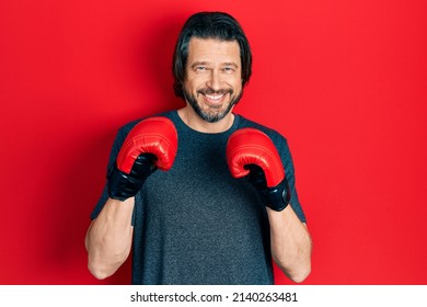 Middle age caucasian man using boxing gloves smiling with a happy and cool smile on face. showing teeth.  - Powered by Shutterstock