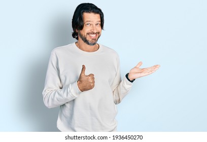 Middle age caucasian man wearing casual clothes showing palm hand and doing ok gesture with thumbs up, smiling happy and cheerful  - Shutterstock ID 1936450270