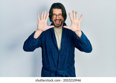 Middle age caucasian man wearing bathrobe and glasses showing and pointing up with fingers number ten while smiling confident and happy.  - Shutterstock ID 2053210946
