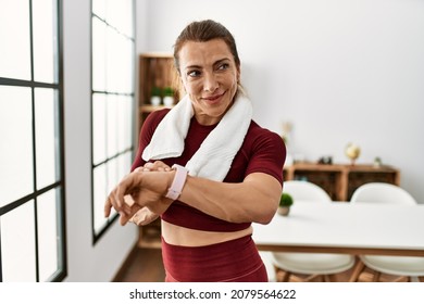 Middle Age Caucasian Sporty Woman Looking Watch At Home.