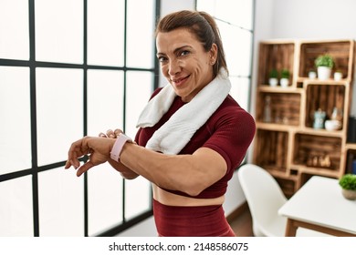 Middle Age Caucasian Sporty Woman Looking Watch At Home.