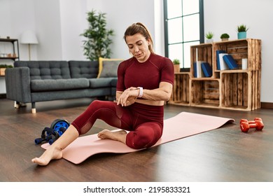 Middle Age Caucasian Sporty Woman Looking Watch At Home.