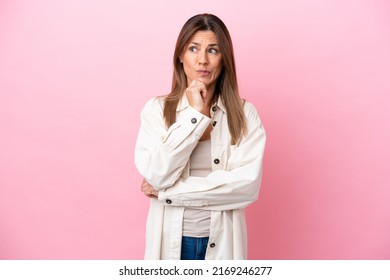 Middle age caucasian woman isolated on pink background having doubts and thinking - Powered by Shutterstock