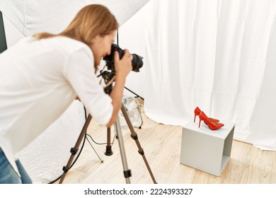 Middle age caucasian woman photographer make picture to high heel shoes at photograph studio - Shutterstock ID 2224393327
