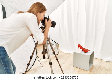 Middle age caucasian woman photographer make picture to high heel shoes at photograph studio - Shutterstock ID 2235256733