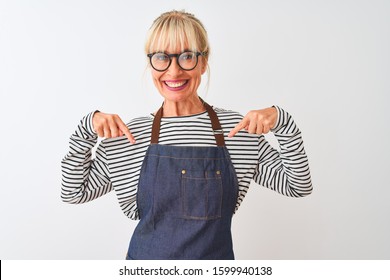 Middle age chef woman wearing apron and glasses over isolated white background looking confident with smile on face, pointing oneself with fingers proud and happy.