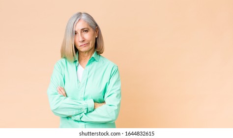 middle age cool woman feeling displeased and disappointed, looking serious, annoyed and angry with crossed arms
