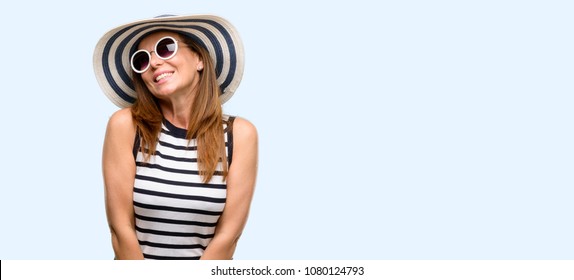 Middle age cool woman wearing summer hat and sunglasses thinking and looking up expressing doubt and wonder isolated blue background