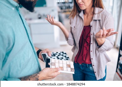 Middle Age Couple Choosing Ceramic Tiles For Their New Bathroom