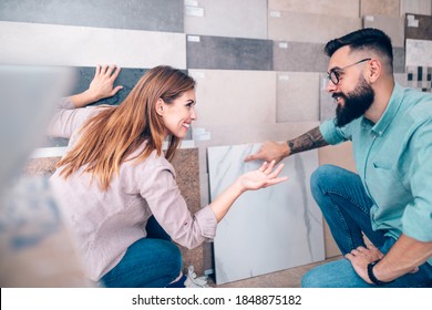 Middle Age Couple Choosing Ceramic Tiles For Their New Bathroom