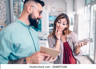 Middle Age Couple Choosing Ceramic Tiles For Their New Bathroom