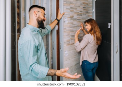 Middle Age Couple Choosing Ceramic Tiler For Their New Bathroom.