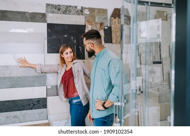 Middle Age Couple Choosing Ceramic Tiler For Their New Bathroom.