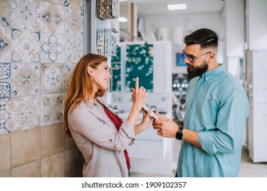 Middle Age Couple Choosing Ceramic Tiler For Their New Bathroom.