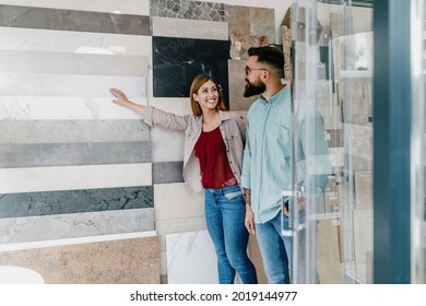 Middle Age Couple Choosing Ceramic Tiles For Their New Bathroom