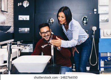 Middle Age Couple Choosing New Ceramic Tiles And Utensils For Their Bathroom