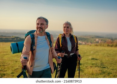 Middle age couple exploring together during weekend. Hiking with the help of hiking poles - Powered by Shutterstock