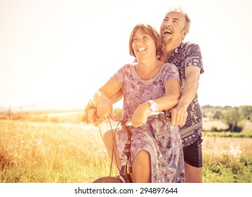 Middle Age Couple Going For A Ride With The Bicycle In The Countryside 