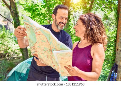 Middle Age Couple  Of Hiker Camping At The Forest. Standing With Smile On Face Looking At The Map.