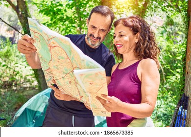 Middle Age Couple  Of Hiker Camping At The Forest. Standing With Smile On Face Looking At The Map.