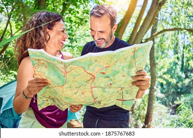 Middle Age Couple  Of Hiker Camping At The Forest. Standing With Smile On Face Looking At The Map.