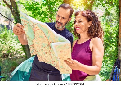 Middle Age Couple  Of Hiker Camping At The Forest. Standing With Smile On Face Looking At The Map.