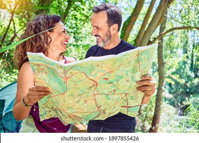 Middle Age Couple  Of Hiker Camping At The Forest. Standing With Smile On Face Looking At The Map.