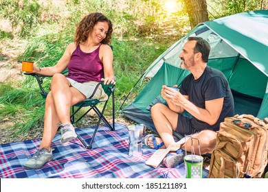 Middle Age Couple  Of Hiker Smiling Happy Drinking Coffee Camping At The Forest.