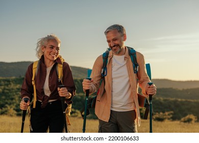 Middle age couple hiking and going camping in nature. Concept of choosing of a right path at the wildlife area.