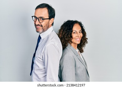 Middle Age Couple Of Hispanic Woman And Man Wearing Business Office Uniform Looking To Side, Relax Profile Pose With Natural Face With Confident Smile. 