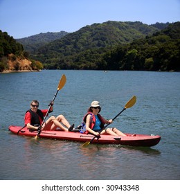 A Middle Age Couple Kayaking On The Lake