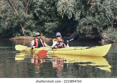 A Middle Age Couple Kayaking In A Tandem Kayak In Danube River At Summer Morning