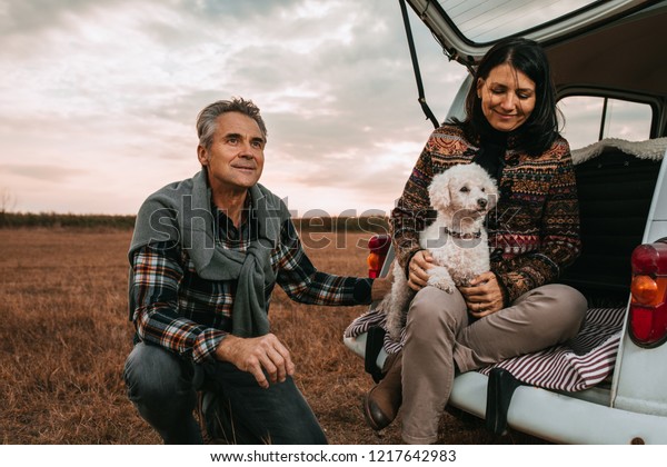 Middle age couple with pet\
at picnic