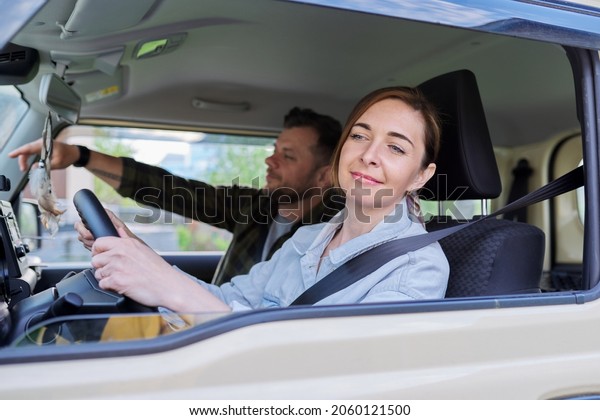 Middle age couple riding in car, woman driver man in\
passenger seat