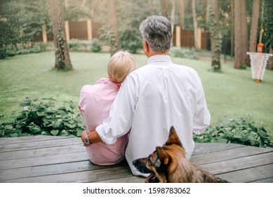 Middle Age Couple Sitting In Their Backyard Together, Rear View