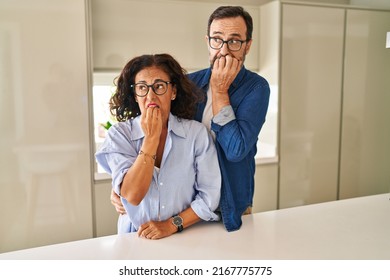 Middle Age Couple Standing Together Looking Stressed And Nervous With Hands On Mouth Biting Nails. Anxiety Problem. 