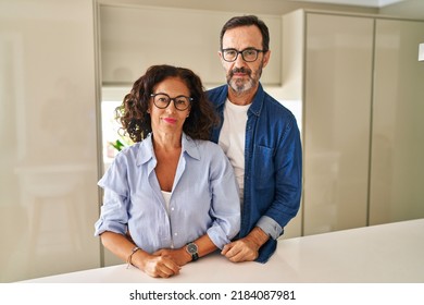 Middle Age Couple Standing Together Relaxed With Serious Expression On Face. Simple And Natural Looking At The Camera. 