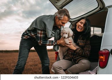 Middle Age Couple With Their Dog At Picnic