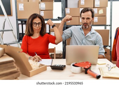 Middle Age Couple Working At Small Business Ecommerce Strong Person Showing Arm Muscle, Confident And Proud Of Power 