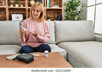 Middle age diabetic woman measuiring glucose using glucometer at home. - Powered by Shutterstock