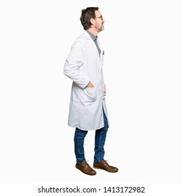 Middle Age Doctor Men Wearing Medical Coat Looking To Side, Relax Profile Pose With Natural Face With Confident Smile.