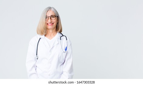 Middle Age Doctor Woman Looking Happy And Goofy With A Broad, Fun, Loony Smile And Eyes Wide Open